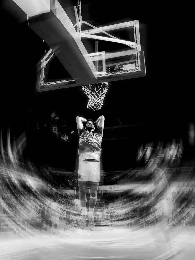 Joueur seul sous le panier, en noir et blanc avec effet de mouvement