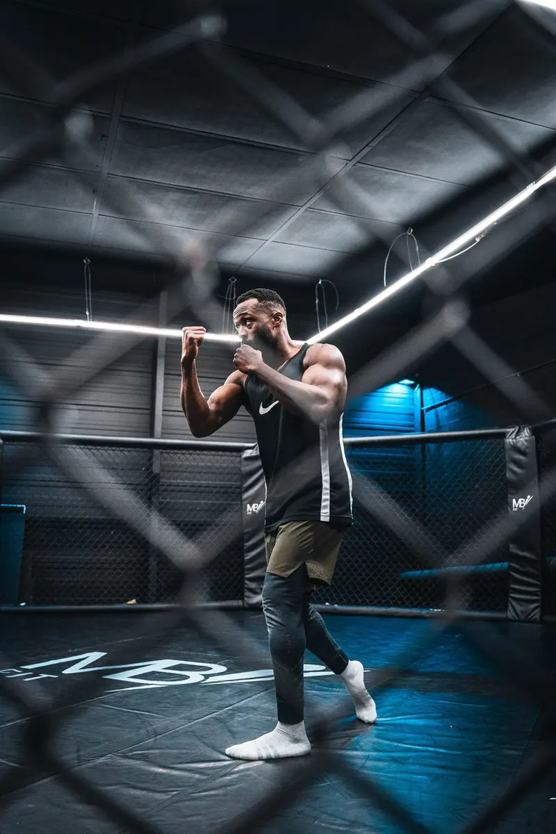 Combattant en garde vu à travers le grillage de la cage